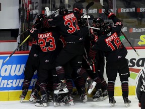 The Moose Jaw Warriors celebrate an overtime goal by Daemon Hunt. Keith Hershmiller Photography.