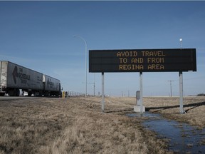 A semi truck travels westbound from Regina while a government sign tells people to avoid the city and area. Yesterday, the government announced increased restrictions because of rising COVID numbers. MICHAEL BELL / Regina Leader-Post