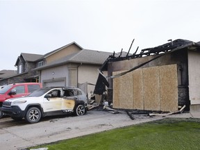 Regina, SASK. : March 15, 2021 -- A burned car sits on the driveway of a home heavily damaged by fire in the 4600 block of Schumiatcher Crescent. Regina Fire and Protective Services responded to the fire around noon Sunday. MICHAEL BELL / Regina Leader-Post