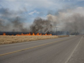 A fire burns in a field adjacent to the north service road off of the TransCanada highway east of Regina, Saskatchewan on April 8, 2021.