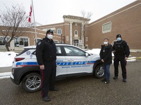 Sgt. Jarod Korchinski, from left, Cst. Kim Carroll and Cst. Cole Lawson, outside Winston Knoll Collegiate in Regina on April 15, 2021, are part of the School Resource Officer program.