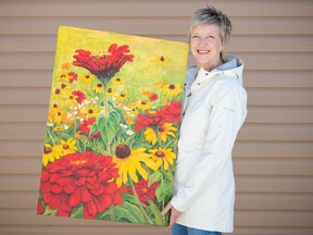 Grandmothers 4 Grandmothers volunteer Sherry Wolf holds "Red Zinnias". Painted by Rose Steadman of Porcupine Plain, SK, the piece will be one of many items included in the auction.