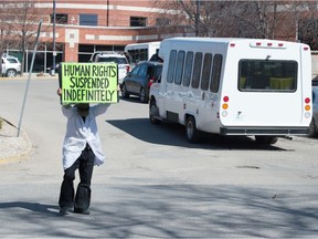A demonstrator stands outside the Regina General Hospital in Regina, Saskatchewan on April 21, 2021. Premier Scott Moe criticized such protesters as COVID-19 patients fill the hospital's ICU.