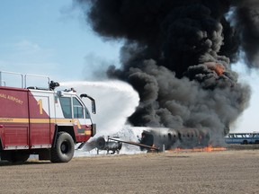 Members of the Regina International Airport Fire Department operate unit Red 1, a a Rosenbauer Panther 6x6 vehicle, to spray foam fire suppressant on a training fire on the airport grounds in Regina, Saskatchewan on April 22, 2021.