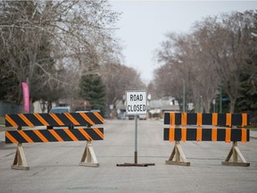 Barricades block the road on Michener Drive in Regina, Saskatchewan on April 26, 2021. A street infrastructure renewal project began there Monday, and the first phase of the project is expected to take six weeks. Work to be completed on the street between University Park Drive and Windfield Road is to include "replacing sidewalks, pedestrian ramps, curbs and gutters, as well as resurfacing the roadway to extend the lifecycle of the road." However, the paving of the street is to be part of phase two, the restrictions around which the city says will be announced "as the work progresses."