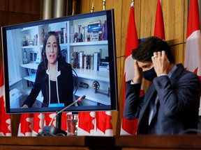 Minister of Public Services and Procurement Anita Anand speaks as Prime Minister Justin Trudeau puts on a face mask during a COVID-19 news conference in Ottawa, March 19, 2021.