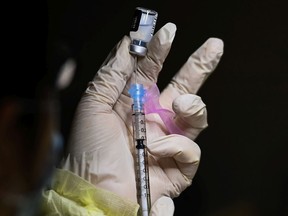 A pharmacist technician fills the Pfizer-BioNTech COVID-19 mRNA vaccine at a vaccine clinic during the COVID-19 pandemic in Toronto on Tuesday, December 15, 2020.