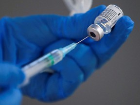 A nurse fills a syringe with a second dose of the Pfizer-BioNTech COVID-19 vaccine.