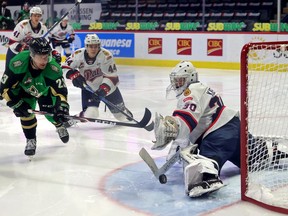 Regina Pats goalie Matthew Kieper (30) makes a save on the Prince Albert Raiders' Eric Pearce (23) at the Brandt Centre on April 13, 2021. Also shown are the Pats' Ryker Evans (41) and Layton Feist (44). Keith Hershmiller Photography.