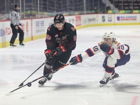 Regina Pats defenceman Parker Berge, right, poke-checks the Moose Jaw Warriors' Brayden Yager at the Brandt Centre on April 5.