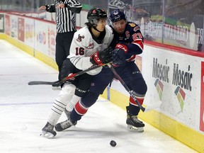 The Moose Jaw Warriors' Maximus Wanner (16) delivers a hit on the Regina Pats' Logan Nijhoff (29) at the Brandt Centre on April 23, 2021. Keith Hershmiller Photography.