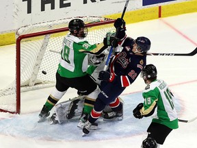Regina Pats' Carter Chorney (22) battles in front of Prince Albert Raiders goaltender Max Paddock with Tre Fouquette (38) on April 18, 2021 at the Brandt Centre. Keith Hershmiller Photography.