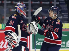 Regina Pats defenceman Ryker Evans (41) congratulates goaltender Roddy Ross (31) after a 6-1 victory over the Current Broncos on April 6, 2021 at the Brandt Centre. Keith Hershmiller Photography.