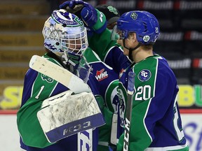 Swift Current Broncos' Braeden Lewis (20) congratulates goaltender Isaac Poulter after Thursday's 8-5 win over the Moose Jaw Warriors at the Brandt Centre.