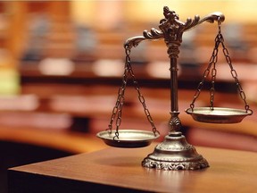 A decorative figure of the Scales of Justice photographed in a courtroom.