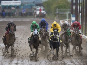 Naim Samara, in green, riding Miss Camelot battles for the lead with Garfield Gordon, in yellow, riding the horse Devirow during the second race at Marquis Downs in Saskatoon on July 21, 2017.