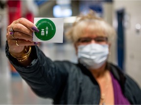 Melinda LaRose brandishes a vaccination certificate sticker after receiving her first dose of a vaccine developed by Pfizer and BioNTech.