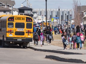 School buses wait to pick up students at Ecole Wascana Plains School in Regina, Saskatchewan on May 3, 2021, the first day back to in-person learning after schools went remote due to COVID-19.