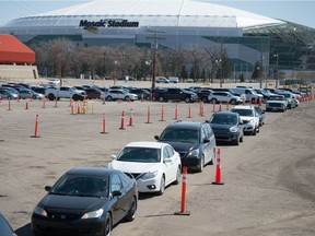 Vehicles line up for the drive-thru COVID-19 vaccine clinic at Evraz Place in Regina, Saskatchewan on May 4, 2021.