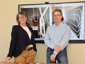 Aura Lee MacPherson, left, and her husband Murdoch stand in front of images of their radiant link heat technology inside MacPherson Engineering in Regina, Sask. on Monday, May 10, 2021. TROY FLEECE / Regina Leader-Post