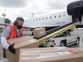 Darrell Novenski, an Air Canada lead, loads boxes carrying ventilators on to a plane at the Regina International Airport in Regina, Saskatchewan on May 12, 2021. The ventilators are being sent as a donation to India, to assist with that country's fight against the COVID-19 pandemic.