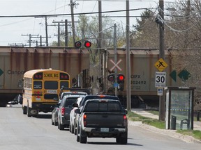 Vehicles wait as a train makes its way through the Eastview neighbourhood in Regina, Saskatchewan on May 12, 2021.