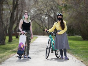 Sydney Chadwick, left, and Ada Dechene, board members of Friday for Future Regina, stand in Wascana Park near the Royal Saskatchewan Museum in Regina, Saskatchewan on May 13, 2021. They've launched a new initiative called Easy Breezy Bike Challenge, asking people to film themselves taking eco-friendly transit around the city.