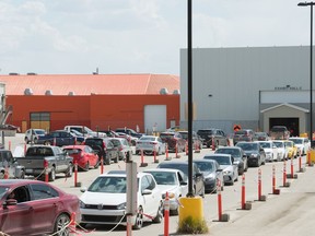 Vehicles line up at a drive-thru COVID-19 vaccine clinic at Evraz Place in Regina, Saskatchewan on May 14, 2021.