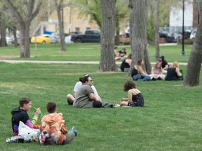 Groups of people relax on the grass in Victoria Park in Regina, Saskatchewan on May 15, 2021.