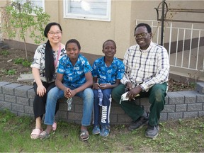 Lydia Nguyen, from left, Benedict Kivuli, Emmanuel Makpe and Ponziano Aluma sit in front of their family home in Regina on May 18, 2021.