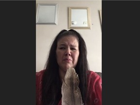 Odelia Quewezance speaks while holding an eagle feather during a Zoom call on Tues., May 18, 2021. Sisters Odelia and Nerissa Quewezance who were convicted of second-degree murder in 1994. The sisters and their supporters say they are innocent and are calling on the federal government to release them. (Screenshot by Heather Polischuk)