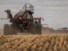 A tractor pulls a seeding drill through a field near Saskatoon on Friday, May 21, 2021.