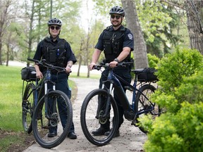 S/Cst Sinclair, left and S/Cst Worona, Community Safety Officers, stand with their bicycles in Wascana Park in Regina, Saskatchewan on May 26, 2021. The officers will be using the bicycles to patrol the park.