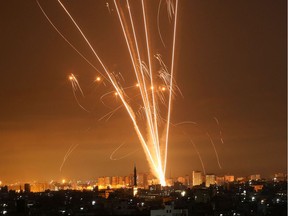 Rockets light up the night sky as they are fired towards Israel from Beit Lahia in the northern Gaza Strip on May 14, 2021. - Israel pounded Gaza and deployed extra troops to the border as Palestinians fired barrages of rockets back, with the death toll in the enclave on the fourth day of conflict climbing to over 100.