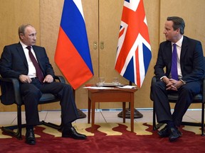 Russia's President Vladimir Putin (L) speaks with Britain's Prime Minister David Cameron (R) as they meet at Charles De Gaulle Airport in Paris on June 5, 2014, during Putin's stopover in the French capital, ahead of Friday's D-Day anniversary ceremony in Normandy. Cameron arrived for his meeting with Putin directly from a Brussels meeting of G7 leaders which issued a warning that Russia faced further sanctions if it does not stop what they see as efforts to destabilise Ukraine.  AFP PHOTO / RIA-NOVOSTI/ POOL/ ALEXEI NIKOLSKY