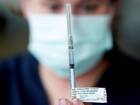 A health-care professional prepares a dose of the Pfizer coronavirus disease (COVID-19) vaccine.