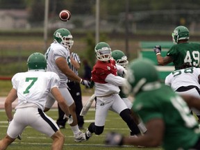 Quarterback Colt Brennan, in the red jersey, throws a pass to Weston Dressler, 7, during the Saskatchewan Roughriders' training camp in Saskatoon on June 8, 2012. Brennan died Monday in Newport, Calif., at age 37.