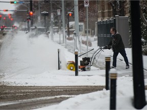 A man uses a sweeping machine to clear snow on Victoria Avenue in Regina on Nov. 19, 2020.