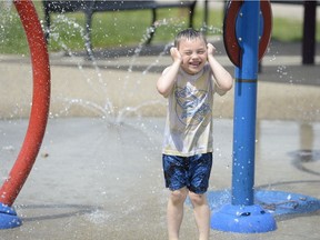 Four-year-old Malakai Johnstone cools off at the spray park near the Core Ritchie Neighbourhood Centre in Regina, Saskatchewan on June 2, 2021.