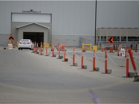 A single vehicle passes through the empty queue lines at the drive-thru vaccine clinic at Evraz Place in Regina, Saskatchewan on June 8, 2021.