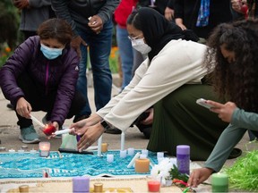 People light candles at a vigil for the lives lost in an attack against a London, Ontario Muslim family at the Saskatchewan Legislative Building in Regina, Sask. on June 9, 2021.