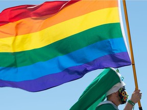 A person waves a flag from a float during the annual Queen City Pride Parade in Regina, Saskatchewan on June 12, 2021. Due to the continued presence of the COVID-19 pandemic, the parade was pared back to a smaller number of floats and allowed no one to walk in the procession. BRANDON HARDER/ Regina Leader-Post