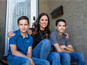 Andrea Wilm sits with her sons Logan, left, and Ryder. Logan and Ryder both have diabetes and have benefitted from the province's decision to cover the cost of equipment.