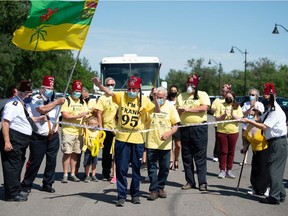 Frank Atchison, visible here with his arms up wearing a shirt with the number 95, crosses a finish line at the end of a 260-kilometre walk in front of the Saskatchewan Legislative Building in Regina, Saskatchewan on June 15, 2021. Atchison, a Shriner, walked from Saskatoon both to celebrate his 95th birthday and to raise money for the Jim Pattison Children's Hospital and Shriners Hospitals for Children.