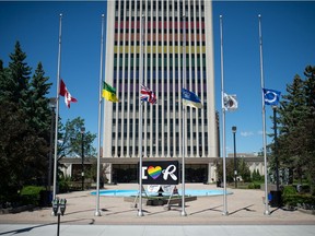 Flags fly at half mast in front of Regina City Hall in Regina, Saskatchewan on June 16, 2021. The flags were not initially flown at half mast following the on-duty death of RCMP Const. Shelby Patton, but were lowered after public outcry that prompted a policy change.