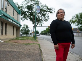 Joely BigEagle-Kequahtooway stands on Dewdney Avenue in Regina, Saskatchewan on June 24, 2021. Behind her, a piece of her art hangs on a light post -- one of a number that can be seen along the avenue. The art is part of what's called the Buffalo Banner Project, which included BigEagle-Kequahtooway providing workshops focused on sharing "Indigenous knowledge and historical education on the buffalo, and the impacts of colonization on Plains Indigenous people." Participants from community groups, schools and local artists created buffalo-themed artwork and select pieces were chosen for the banners, which are meant to be displayed annually. The effort seeks to bring attention to the proposed renaming of Dewdney Avenue.