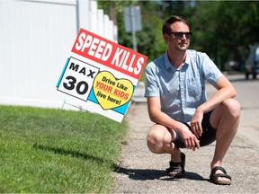 Regina city councillor Andrew Stevens is shown next to a sign that urges motorists to slow down on 15th Avenue in Regina, Saskatchewan on June 30, 2021. Stevens and a resident of his ward (3) created the signs to offer to residents who live on streets where motorists are frequently seen exceeding the speed limit.