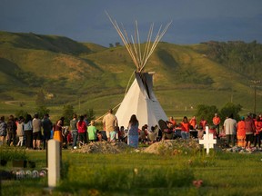 TOPSHOT - Hundreds of people gather for a vigil in a field where human remains were discovered in unmarked graves at the site of the former Marieval Indian Residential School on the Cowessess First Nation in Saskatchewan on June 26, 2021. - More than 750 unmarked graves have been found near a former Catholic boarding school for indigenous children in western Canada, a tribal leader said Thursday -- the second such shock discovery in less than a month.