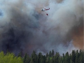 Water droppers battle an out of control forest fire after the city of Prince Albert declared a state of emergency over a fast-moving wildfire, prompting some residents to evacuate, in Prince Albert, Saskatchewan, Canada May 18, 2021. REUTERS/David Stobbe