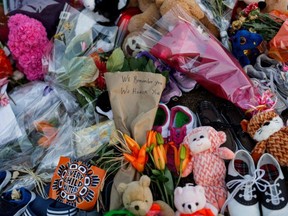 In this file photo taken on June 4, 2021 a message is scrawled on flowers at a makeshift memorial at the former Kamloops Indian Residential School to honour the 215 children whose remains have been discovered buried near the facility, in Kamloops, British Columbia, Canada.